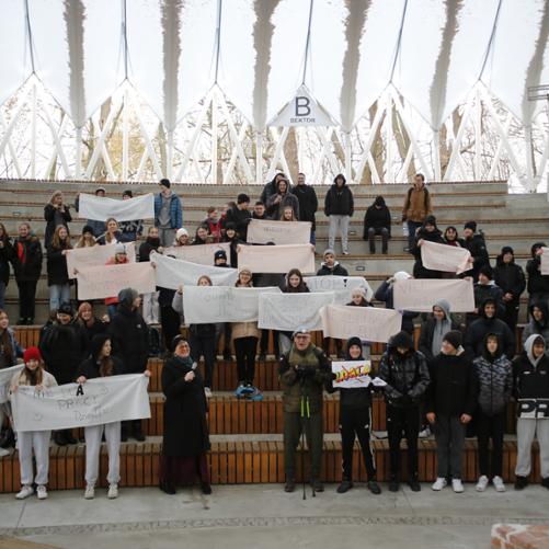 Grupy młodzieży pozują do zdjęcia trzymając banery z hasłami