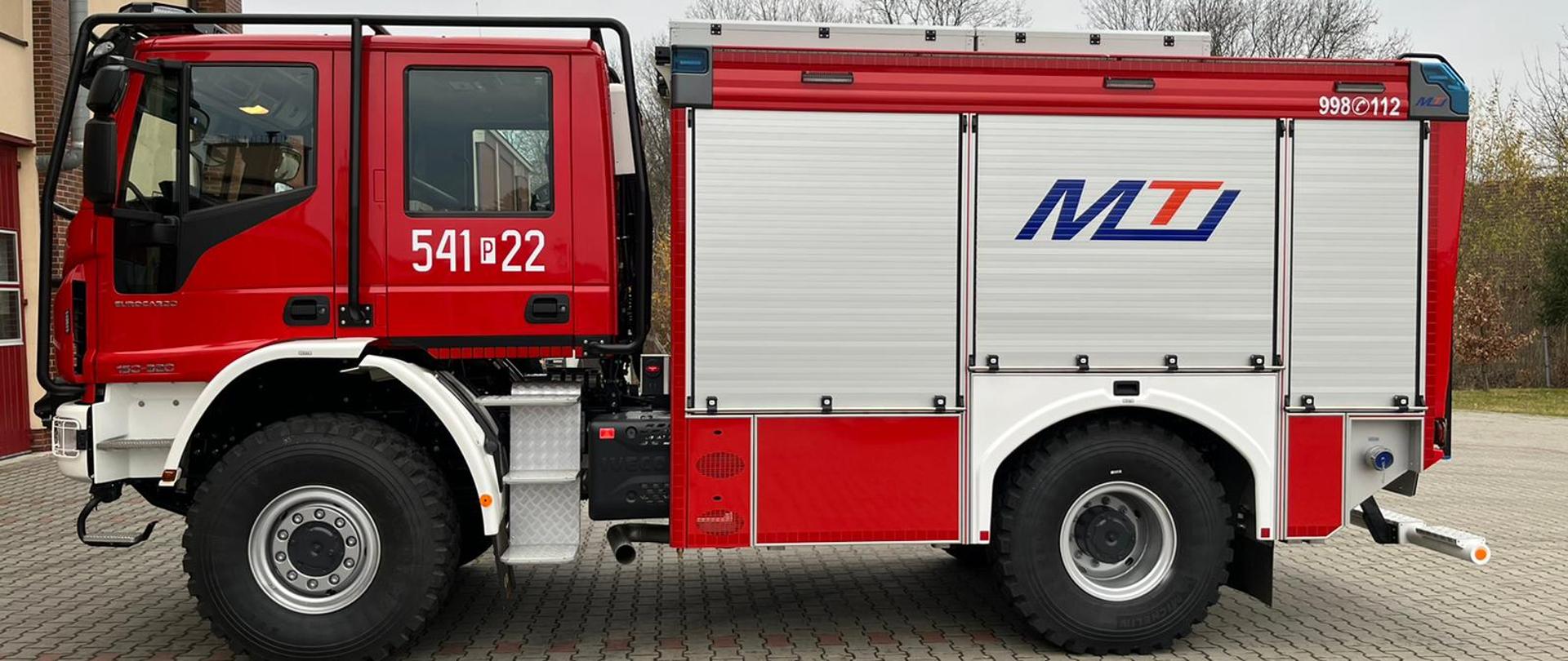 Zdjęcie przedstawia nowy wóz bojowy pozyskany do JRG Ostrzeszów. Na zdjęciu widzimy wóz bojowy wraz z wyposażeniem sprzętowym. Zdjęcie wykonane na planu Komendy w porze dziennej.