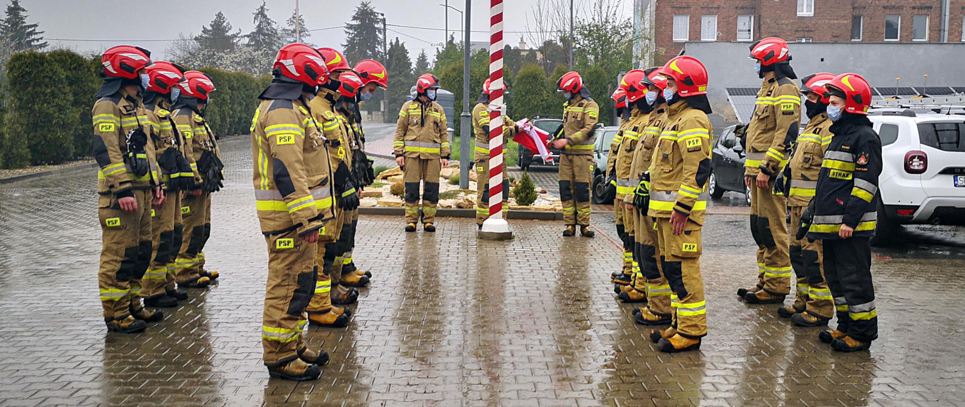 Zdjęcie przedstawia poczet flagowy podnoszący flagę na maszt. Obok w szyku zwartym stoją dwie zmiany służbowe.