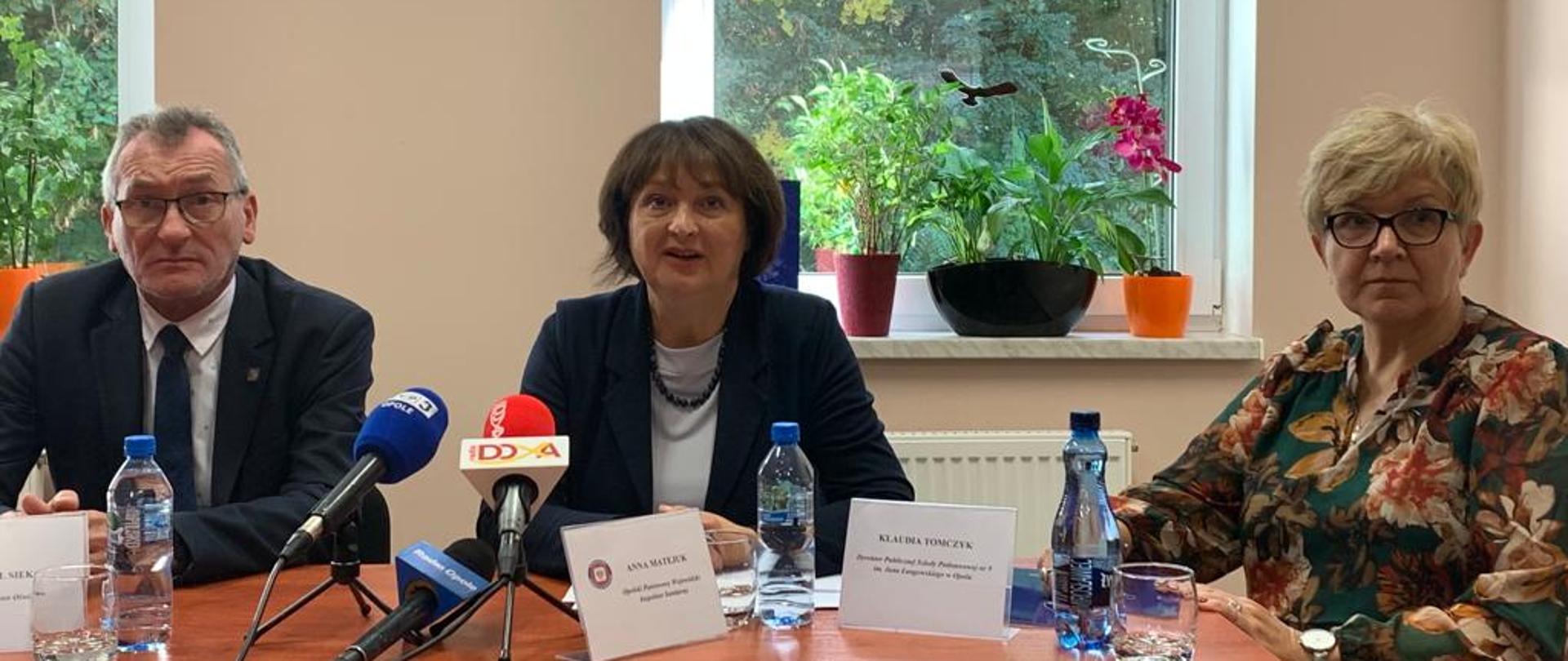 Mężczyzna i dwie kobiety udzielają informacji mediom