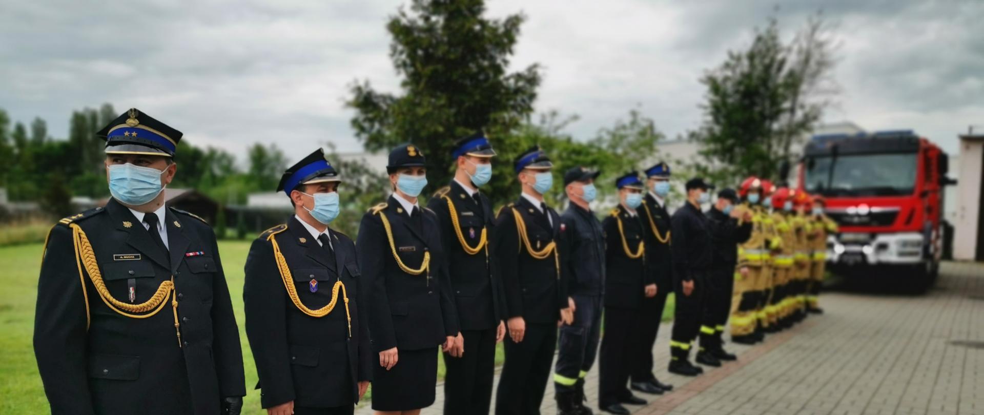 Zdjęcie przedstawia strażaków Komendy Powiatowej PSP w Aleksandrowie Kujawskim stojących na placu przed JRG w Aleksandrowie Kujawskim podczas uroczystości Dnia strażaka