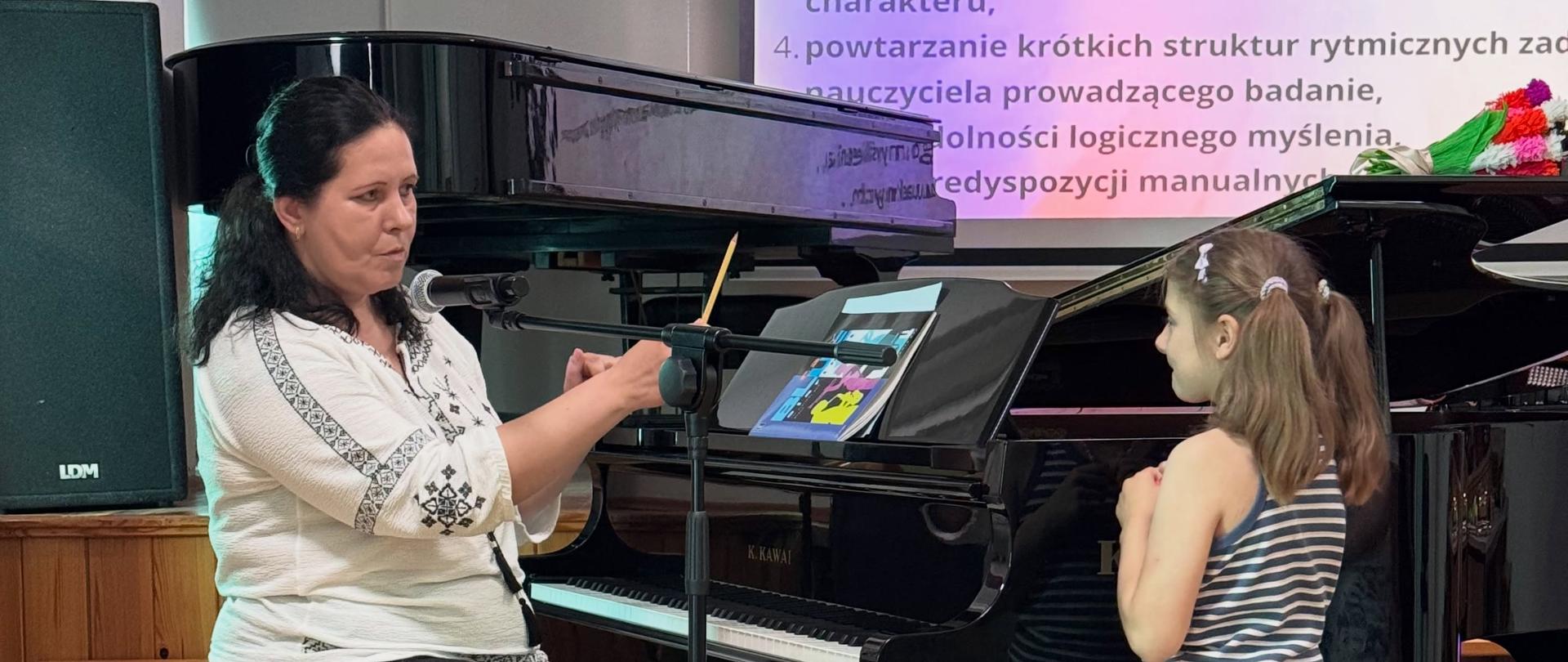 Zdjęcie przedstawiające wykonawców części koncertowej i prowadzących spotkanie dla kandydatów do szkoły pod tytułem niecodzienne spotkanie z muzyką, które odbyło się 25 maja 2026 roku w auli szkoły.