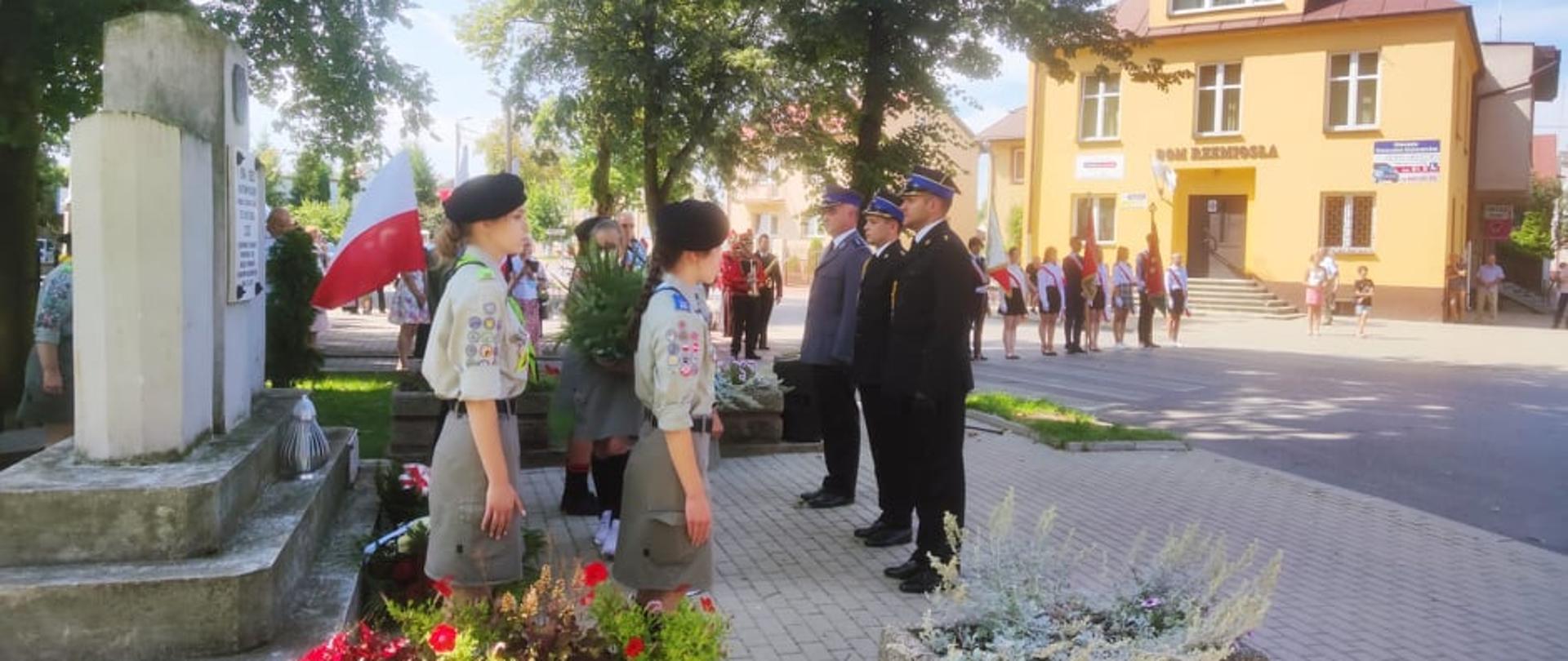 Strażacy razem z policjantem złożyli kwiaty pod pomnikiem podczas uroczystości święta wojska polskiego.