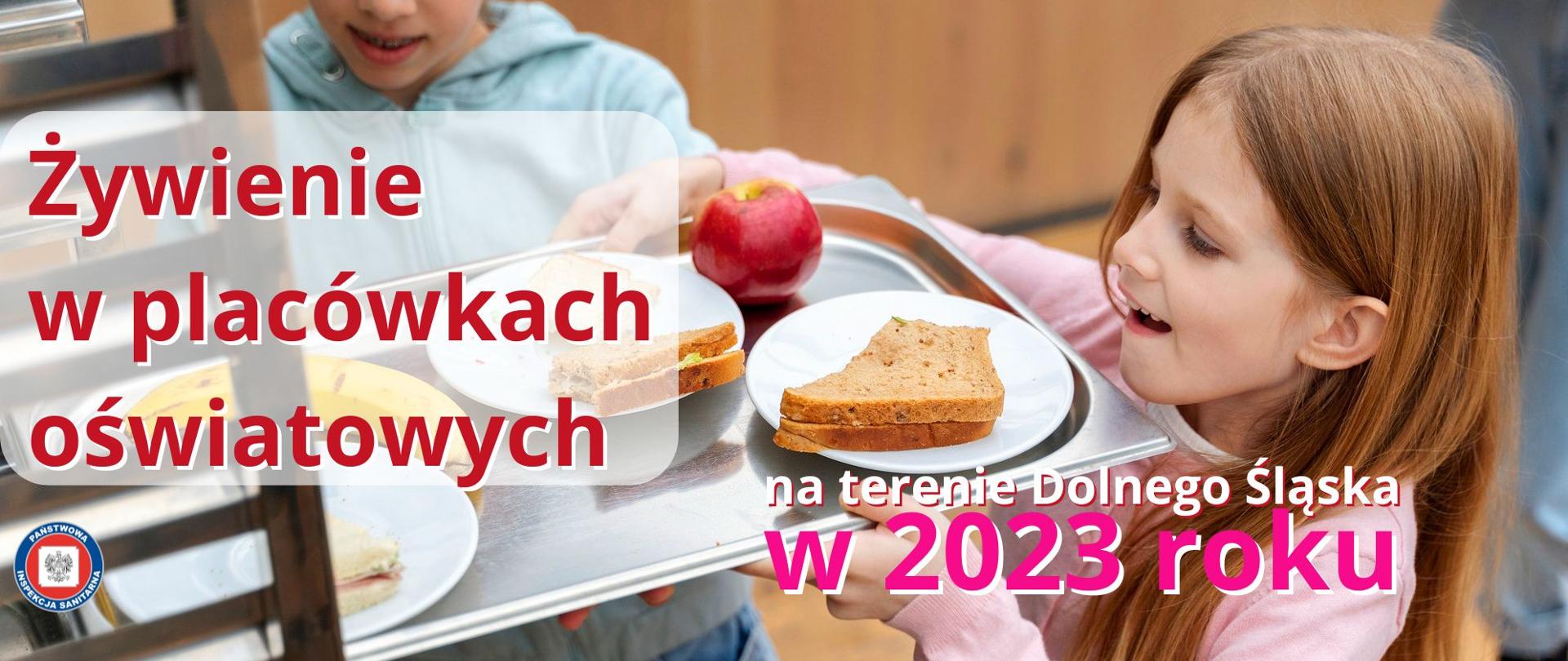 Dziewczynka na szkolnej stołówce trzyma tacę z kanapkami i jabłkiem