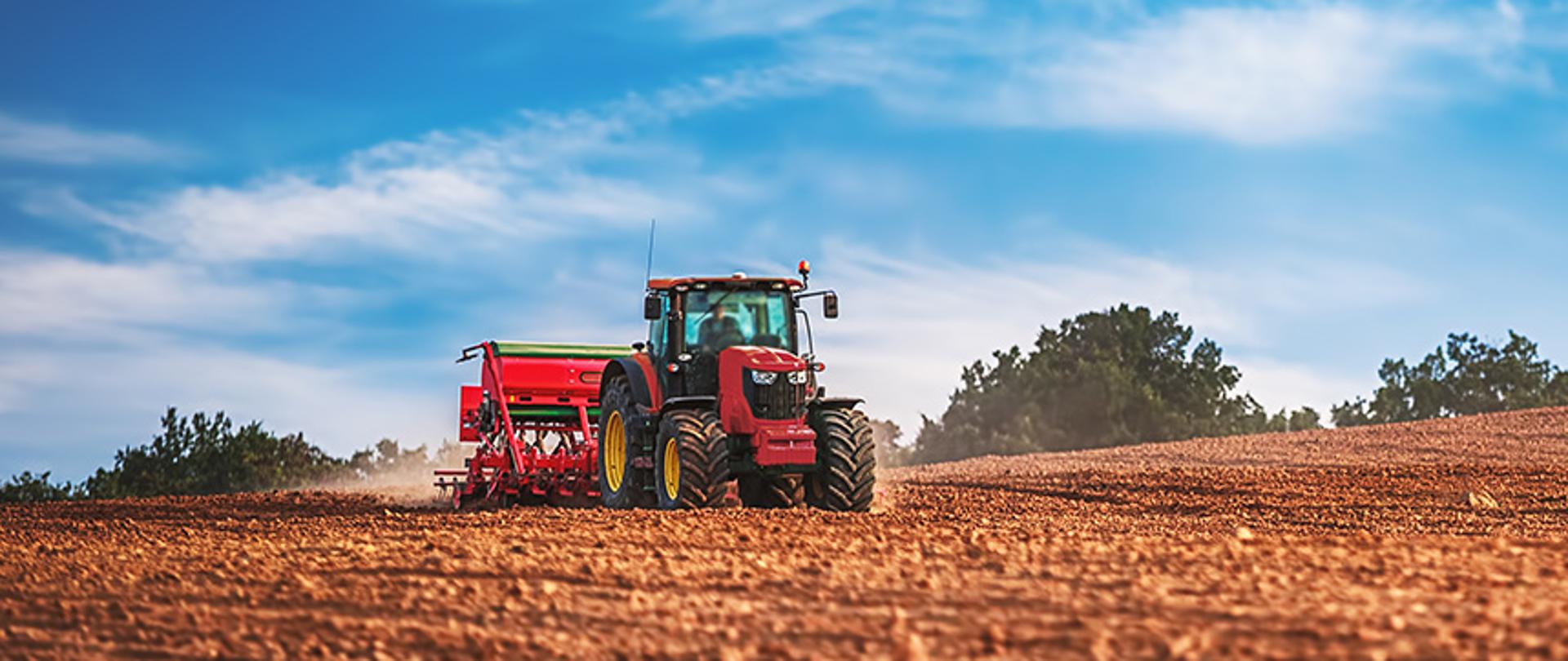 Zdjęcie przedstawia traktor na polu