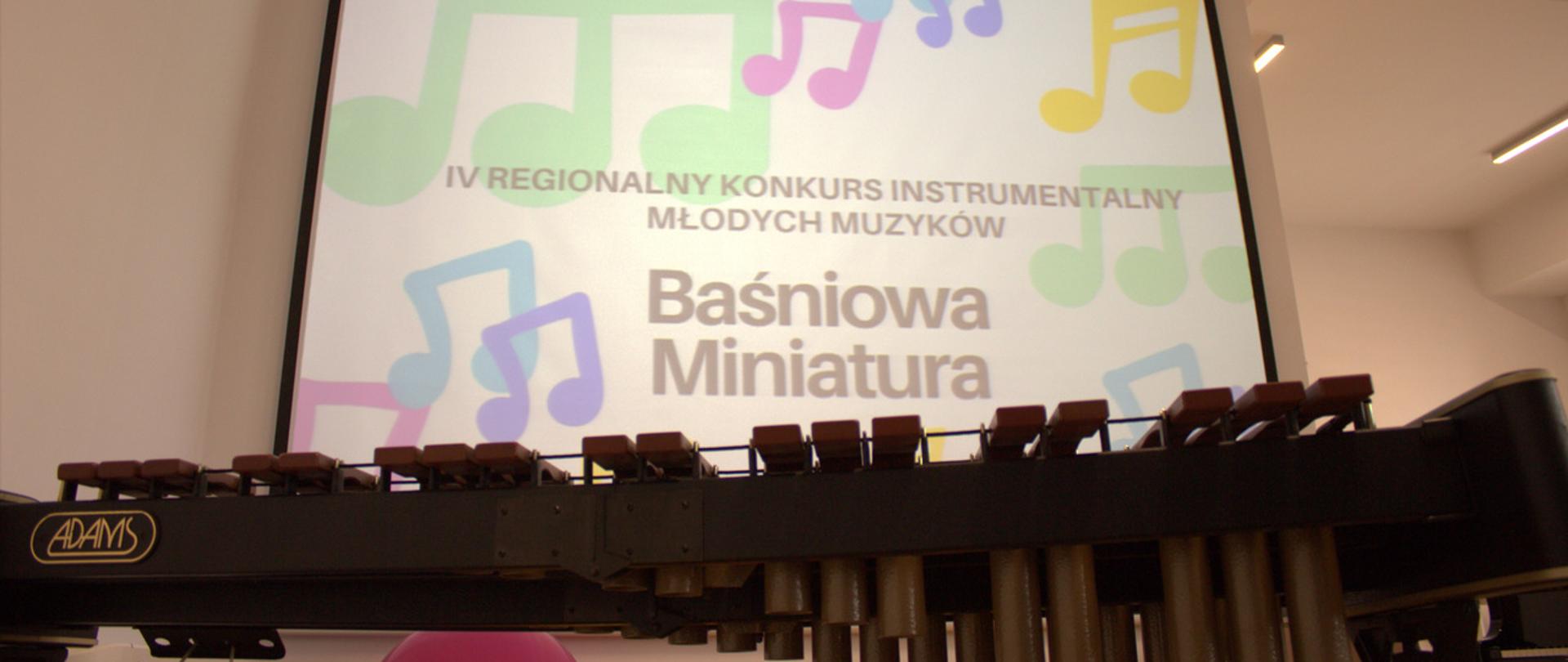 zdjęcie ksylofonu z bliska, nad nim wyświetlany projektor z kolorowym plakatem