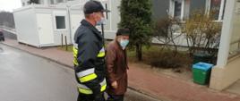 Druh OSP Krynki doprowadza starszego mężczyznę do punktu szczepień w Starachowicach