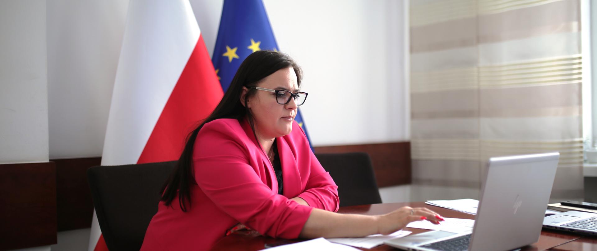 na stole przy biurku i komputerze na którym trwa połączenie grupy roboczej widoczna minister Małgorzata Jarosińska-Jedynak