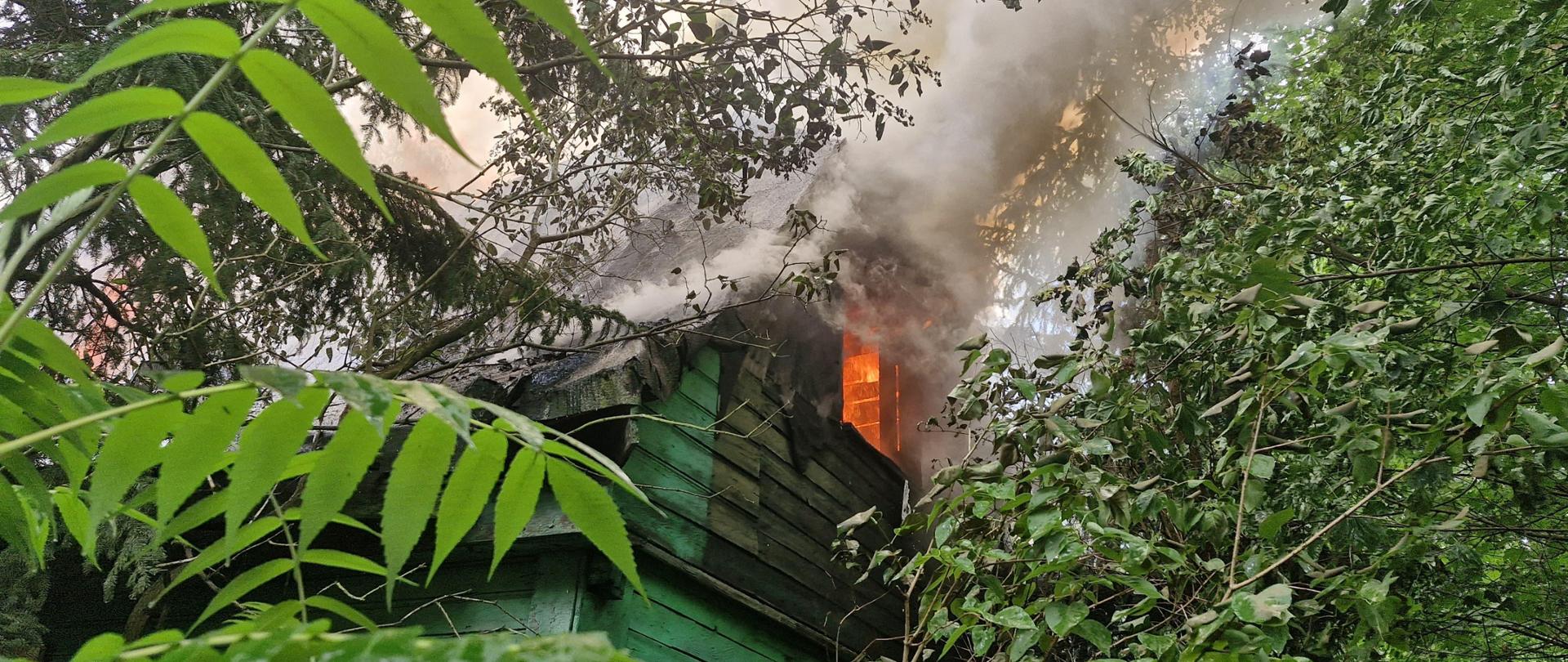 Widok pożaru w szczytowym oknie drewnianego budynku