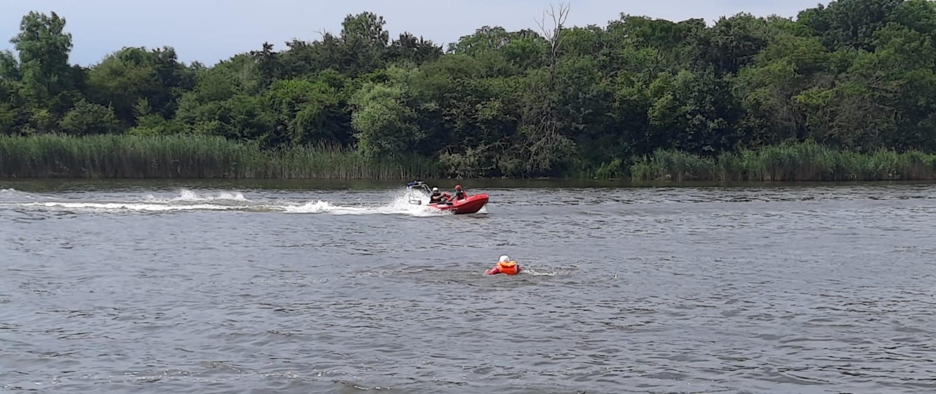 Widać łódź motorową podpływającą do osoby poszkodowanej w wodzie