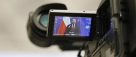 Minister funduszy i polityki regionalnej Grzegorz Puda w podglądzie kamery podczas konferencji prasowej