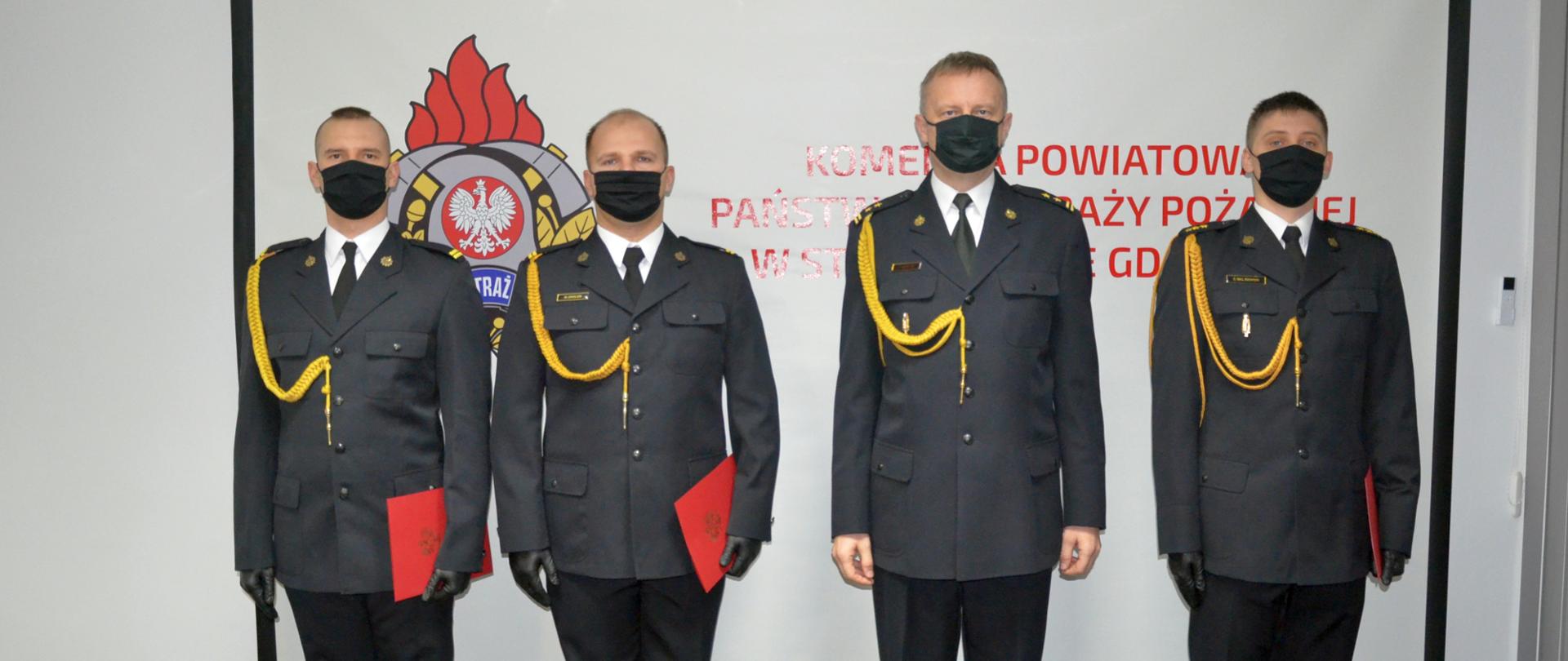 foto przedstawia Komendanta Powiatowego wraz z trzema awansowanymi strażakami