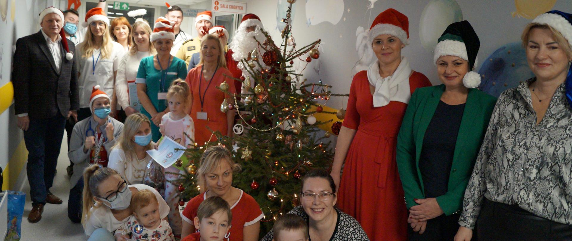 Zdjęcie przedstawia dzieci, rodziców podczas odwiedzin świętego Mikołaja 