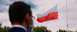 Widok zza premiera na wiszącą flagę Polski.