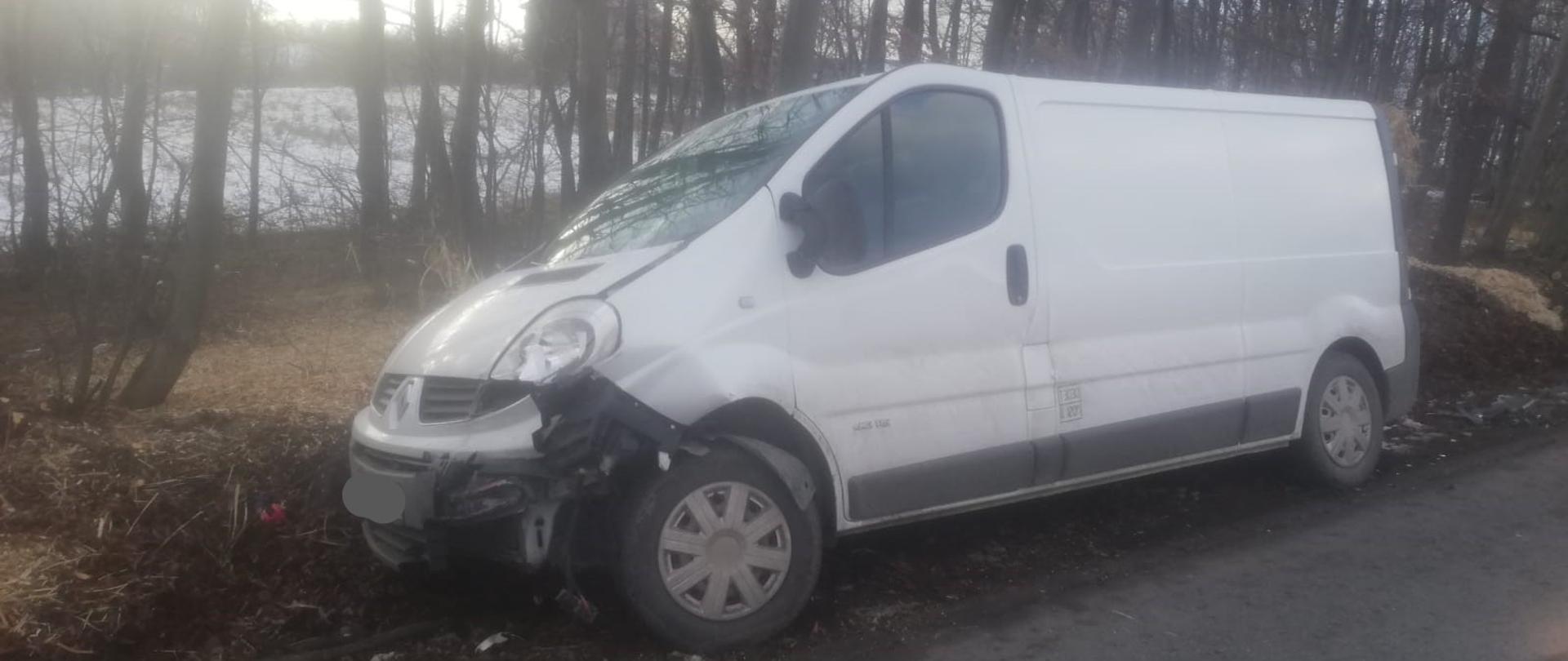 W centralnej części zdjęcia widoczny jest uszkodzony samochód dostawczy