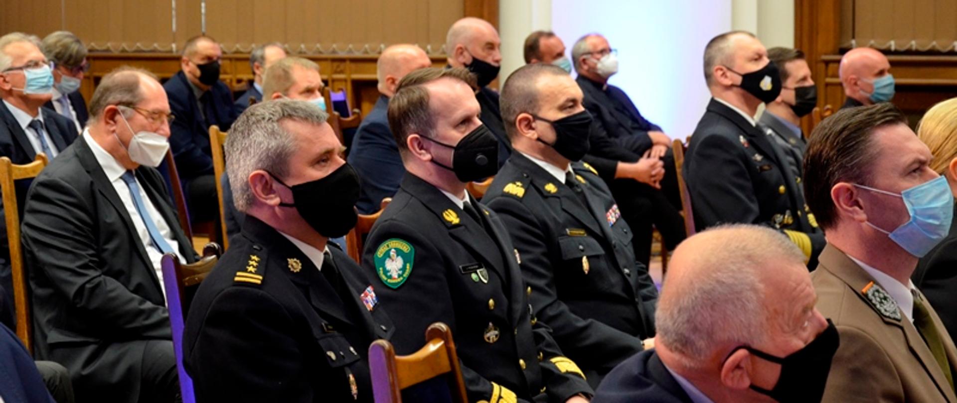 Pomorski komendant wojewódzki Państwowej Straży Pożarnej oraz zaproszeni goście siedzą na spotkaniu konwentu.