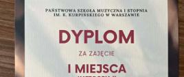 Na jasnym tle czerwone litery Dyplom za zajęcie I miejsca