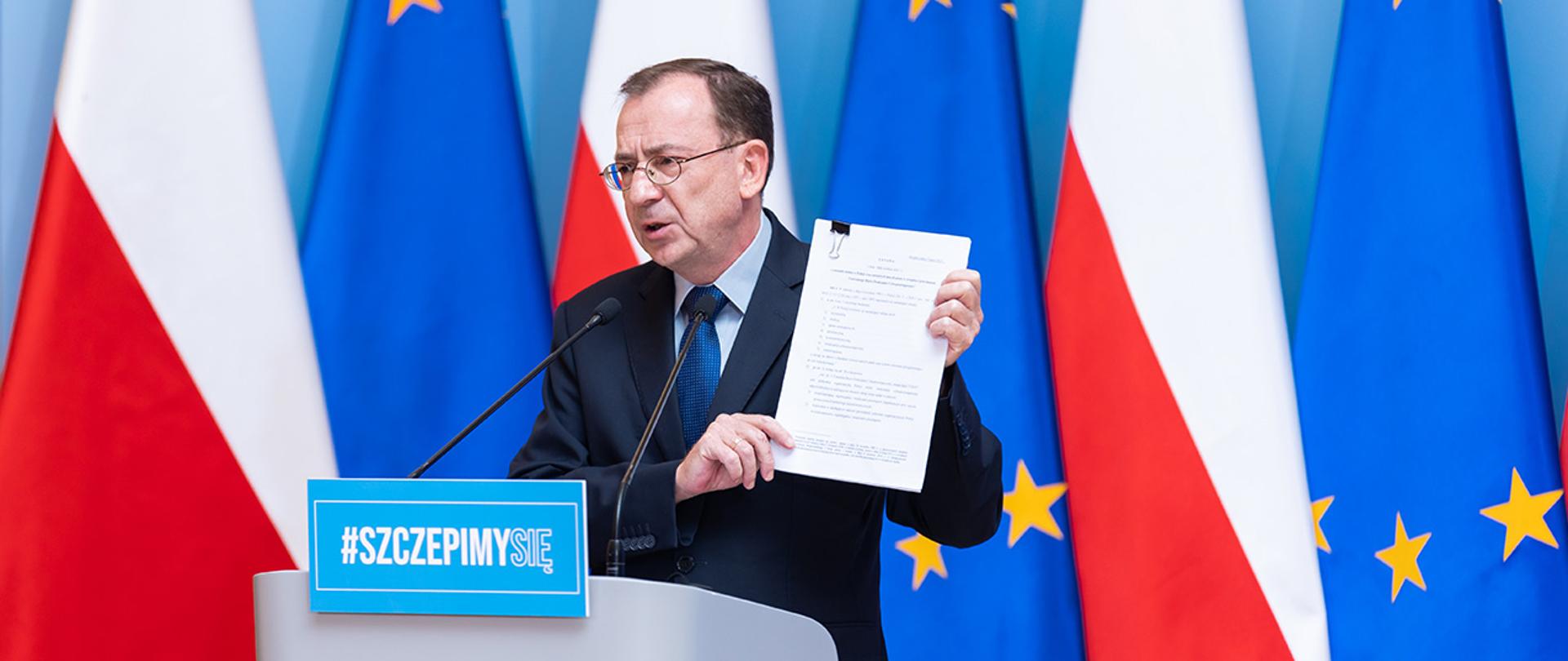 Na zdjęciu widać ministra Mariusza Kamińskiego trzymającego projekt ustawy o powołaniu Centralnego Biura Zwalczania Cyberprzestępczości.