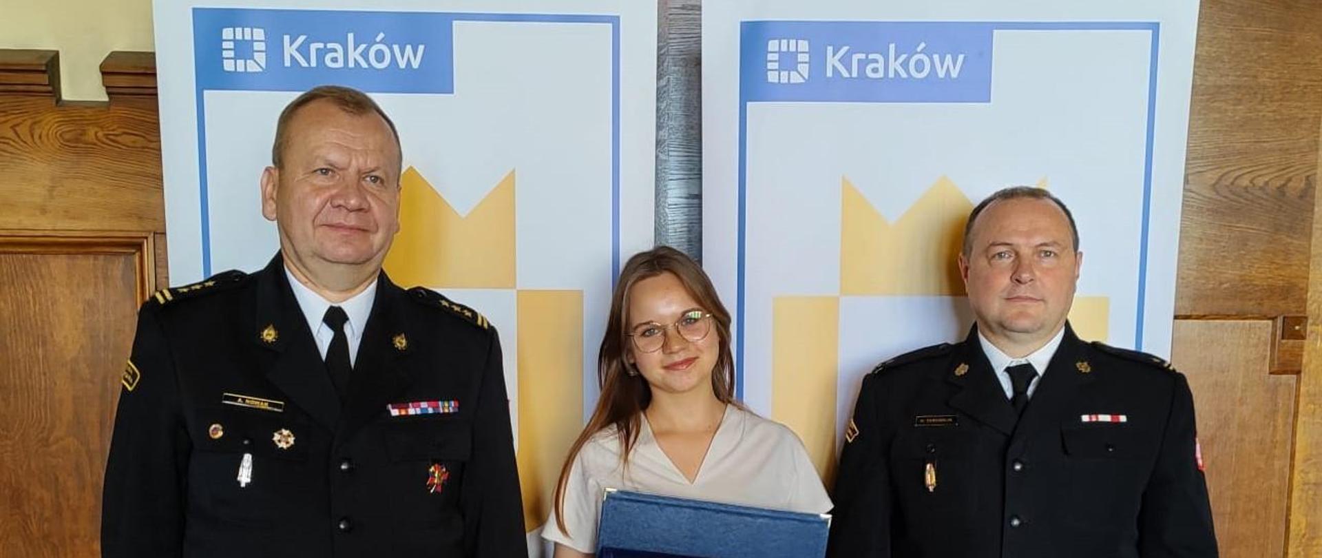 Z-ca Komendanta Miejskiego wraz z przedstawicielką wyróżnionego strażaka KM PSP w Krakowie .