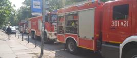 Trzy samochody ratowniczo gaśnicze Państwowej Straży Pożarnej w tym samochód z drabiną mechaniczną.