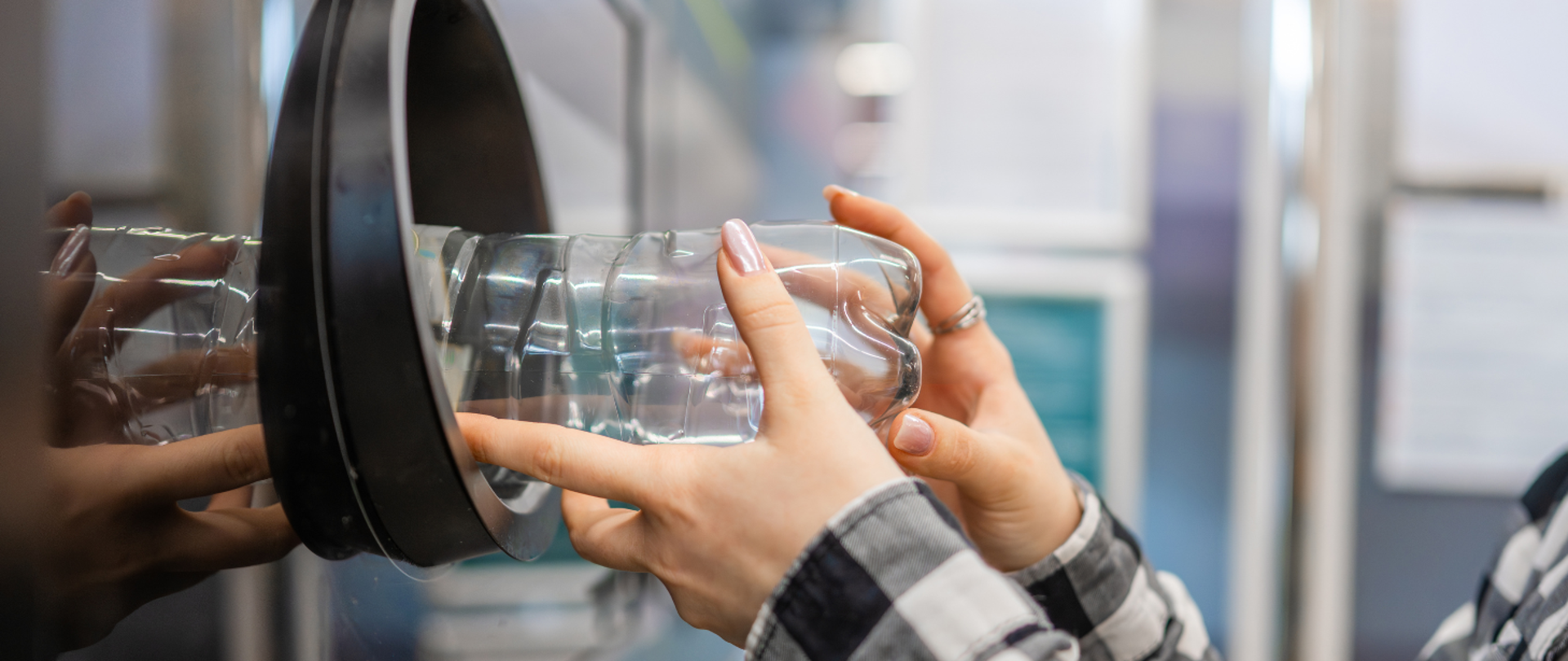 na zdjęciu widnieje postać kobiety, która wrzuca plastikową butelkę do automatu systemu kaucyjnego. 