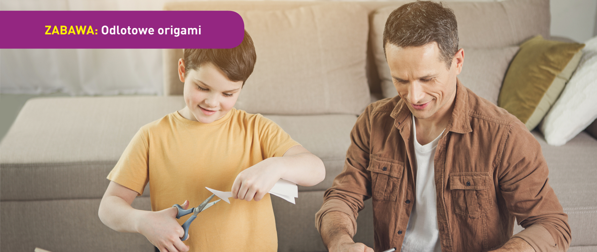 Na zdjęciu widać chłopca z dorosłych, prawdopodobnie jego ojcem. Pracują razem przy niskim stole nad wycinanką z papieru. W tle widać kanapę. U dołu znajduje się pasek logotypów: Europejskie Fundusze Polska Cyfrowa, Ministerstwo Cyfryzacji, NASK i Unia Europejska Europejski Fundusz Rozwoju Regionalnego.