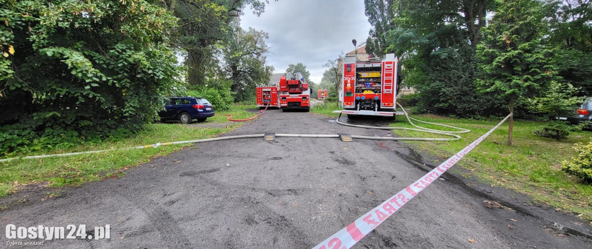 Zdjęcie przedstawia samochody pożarnicze stojące na drodze gruntowej.