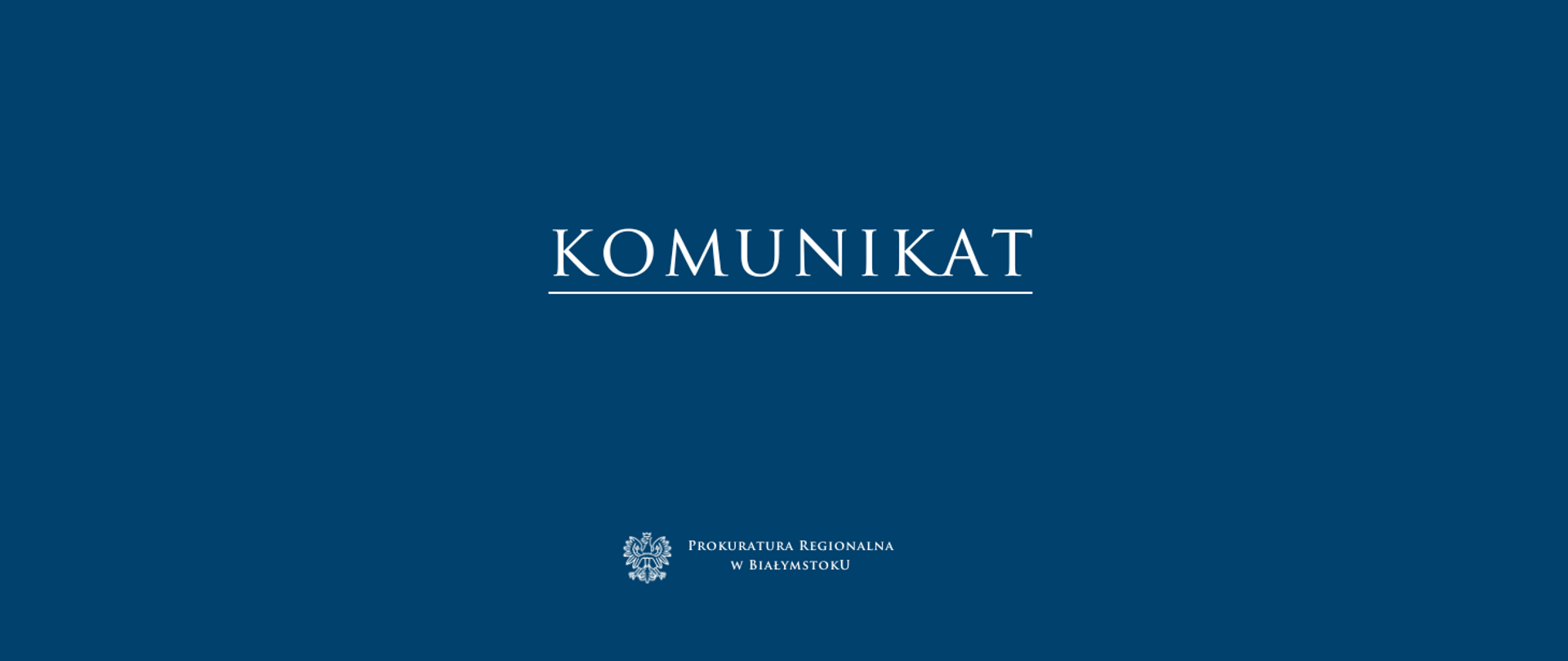 Na ciemnoniebieskim tle znajduje się duży, biały napis „KOMUNIKAT”, podkreślony cienką linią. Pod napisem, na dole banera, widnieje biały logotyp orła oraz tekst: „PROKURATURA REGIONALNA W BIAŁYMSTOKU"