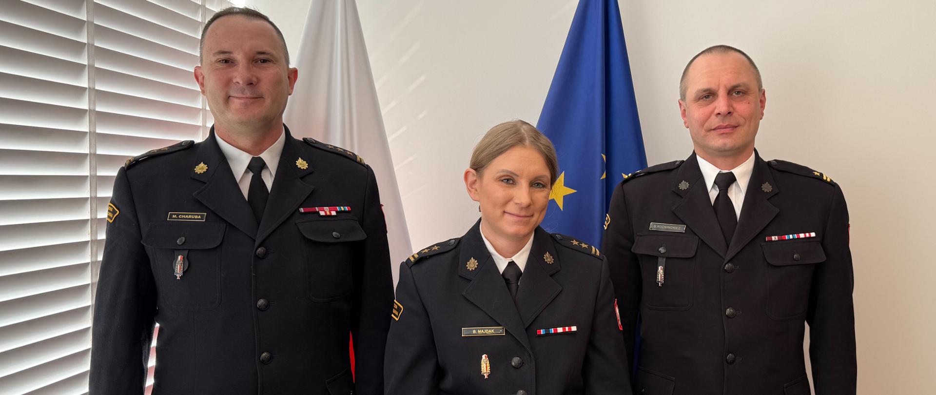 Zdjęcie przedstawia komendantów przy fladze