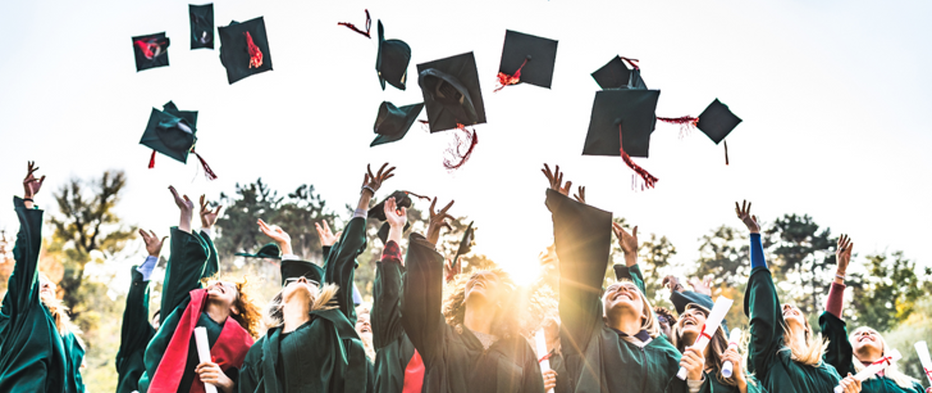 Zdjęcie przedstawiające absolwentów podrzucających swoje czapki.