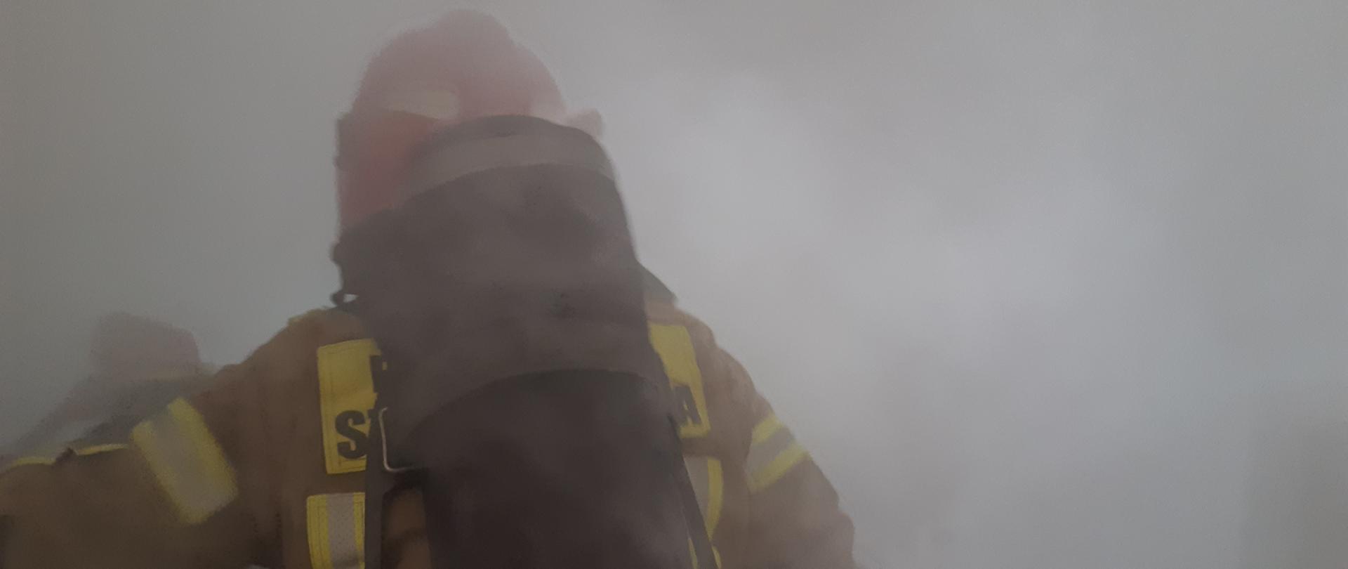 Strażak wchodzący do zadymionego pomieszczenia