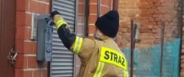 widoczny strażak wkładający ulotkę do skrzynki na listy