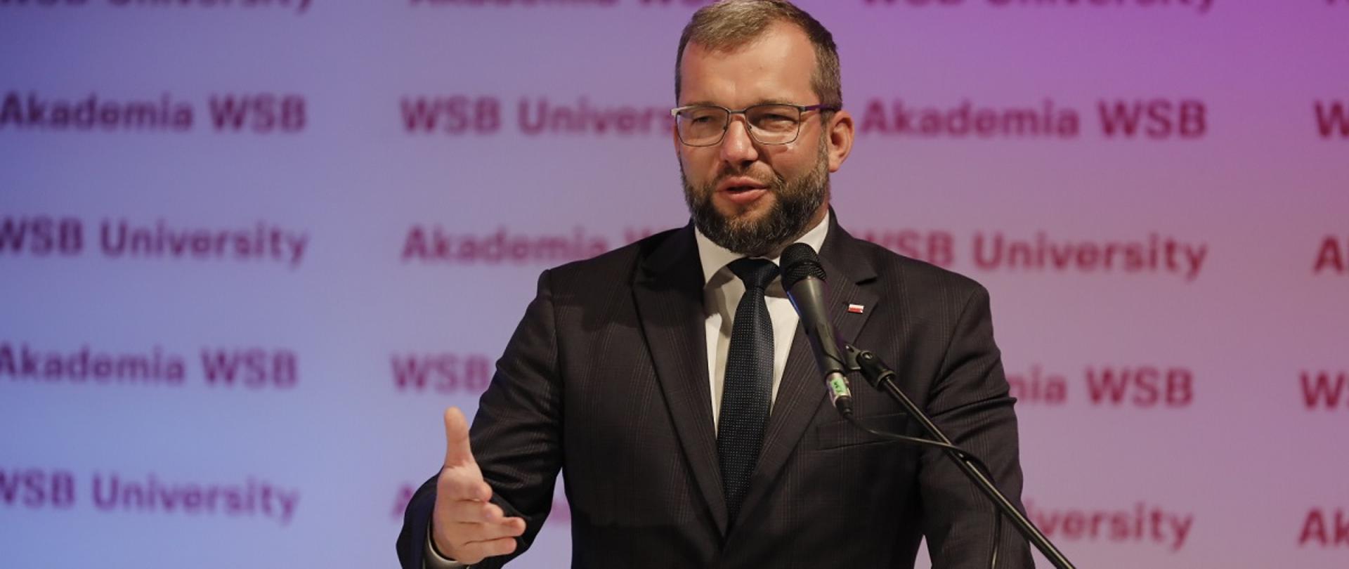Minister funduszy i polityki regionalnej Grzegorz Puda w Akademii Wyższej Szkoły Biznesu w Żywcu, minister stopi przy mikrofonie i mównicy