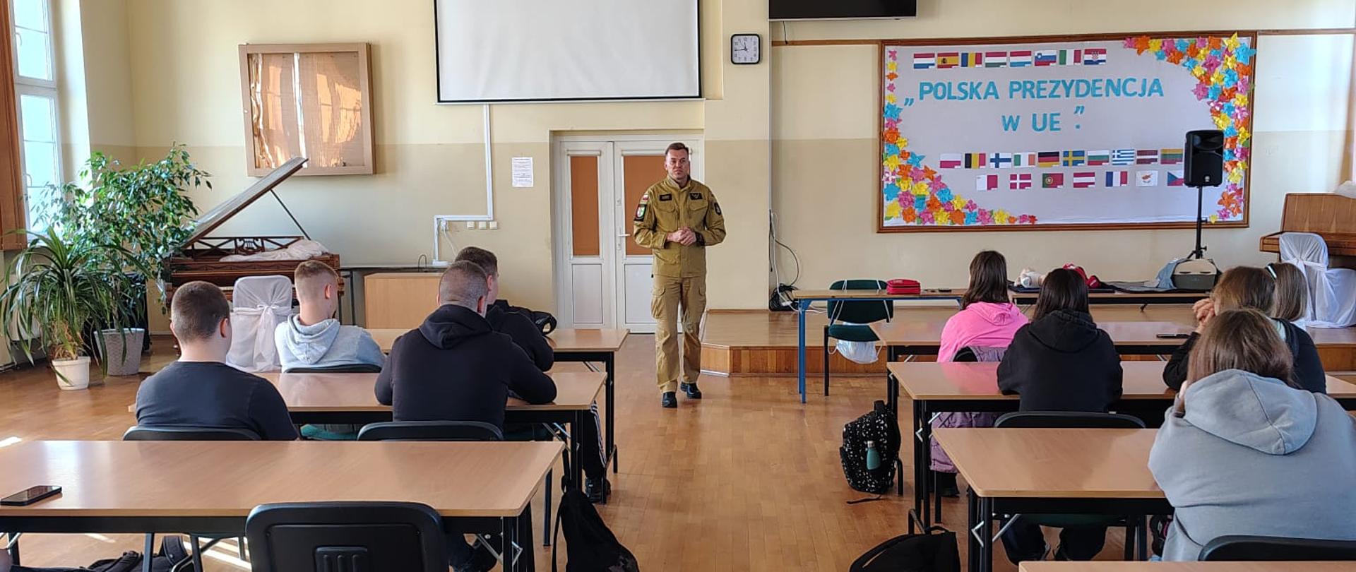 Funkcjonariusz Komendy Powiatowej Państwowej Straży Pożarnej prowadzi zajęcia teoretyczne z Pierwszej Pomocy.