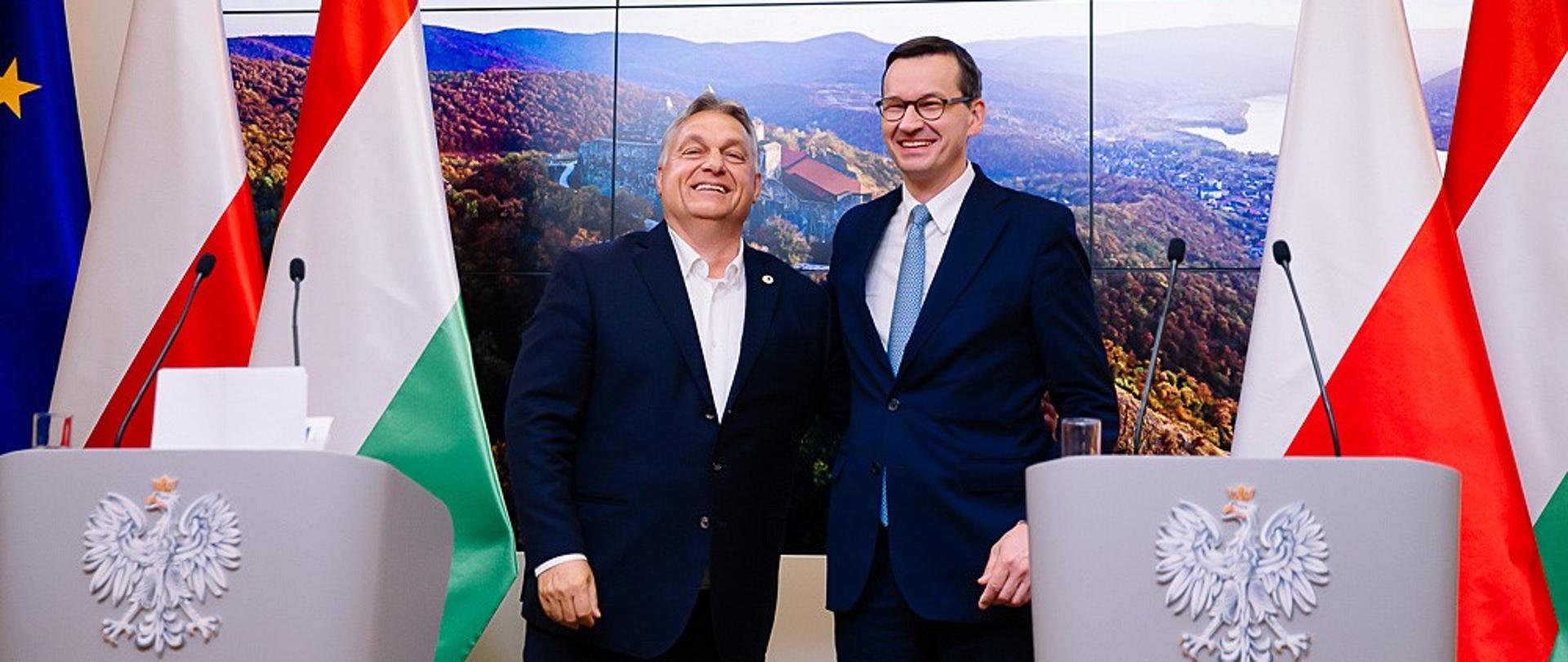 Premier Mateusz Morawiecki i Viktor Orban stoją obok siebie.