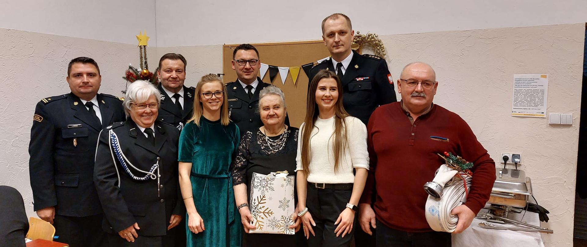 Druhny i druhowie OSP Smykówko pozują do wspólnego zdjęcia wraz z zaproszonymi gośćmi