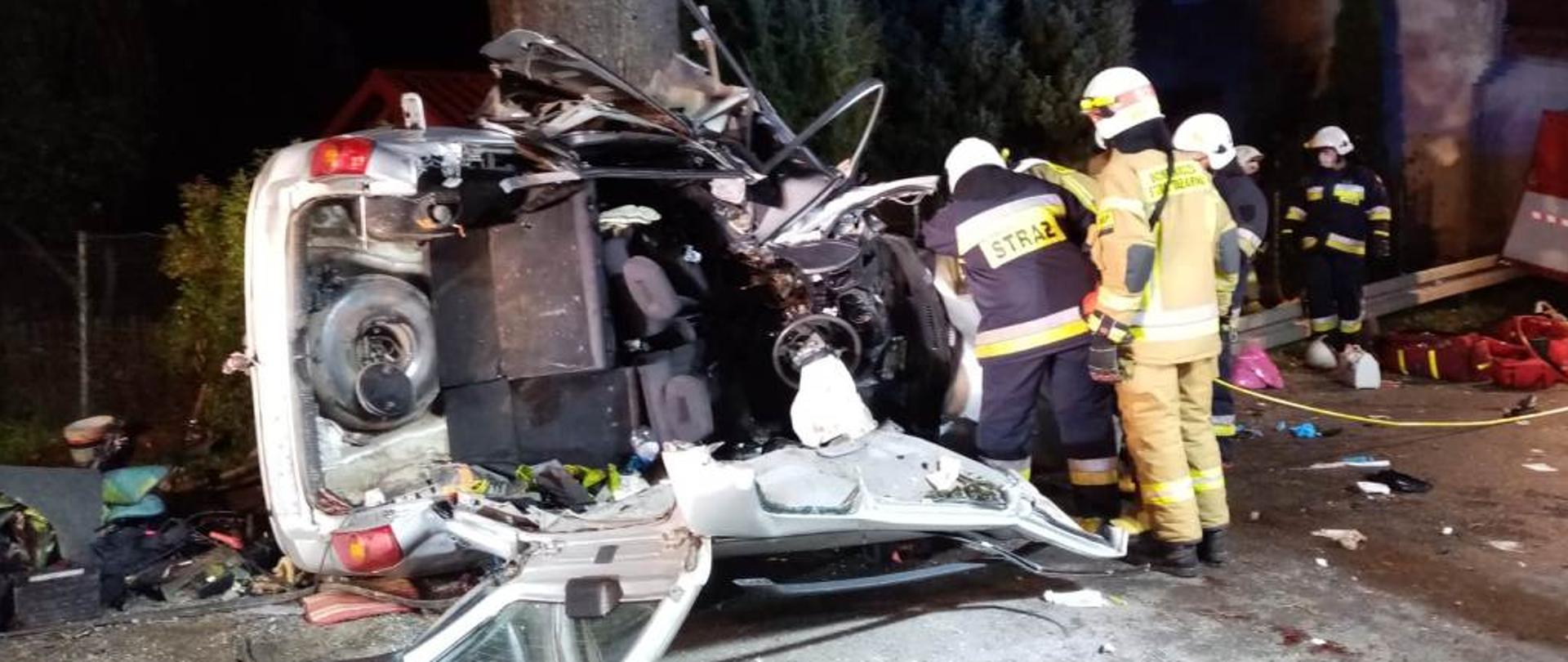 Strażacy używający narzędzi hydraulicznych w celu wydobycia osoby poszkodowanej z samochodu osobowego