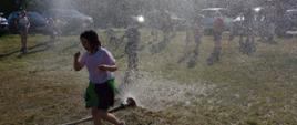Dzieci biegające przy rozłożonej kurtynie wodnej.