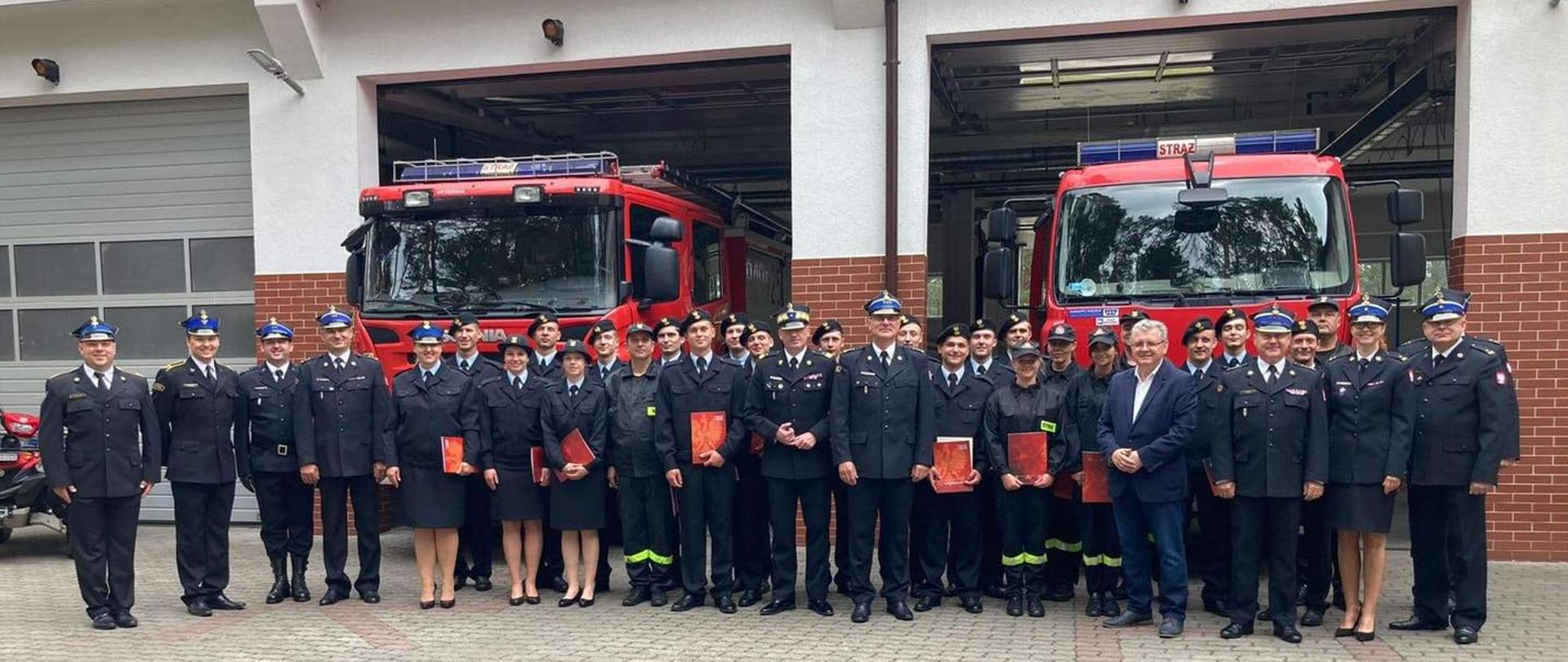 Zdjęcie grupowe z kursantami, kadrą ośrodka oraz zaproszonymi gośćmi. W tle samochody ratowniczo gaśnicze JRG WOSz PSP Borne Sulinowo 