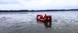 Zdjęcie przedstawia strażaków PSP i OSP w tle jezioro Głuszyńskie podczas ćwiczeń z zakresu ratownictwa lodowego.