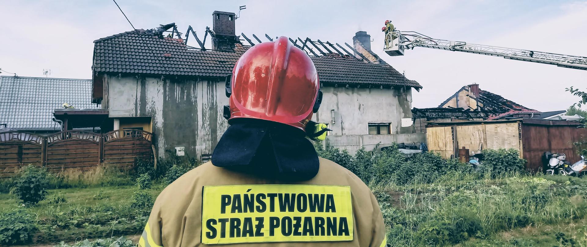 Pożar domu w Kiełpinie - dowódca na tle pogorzeliska