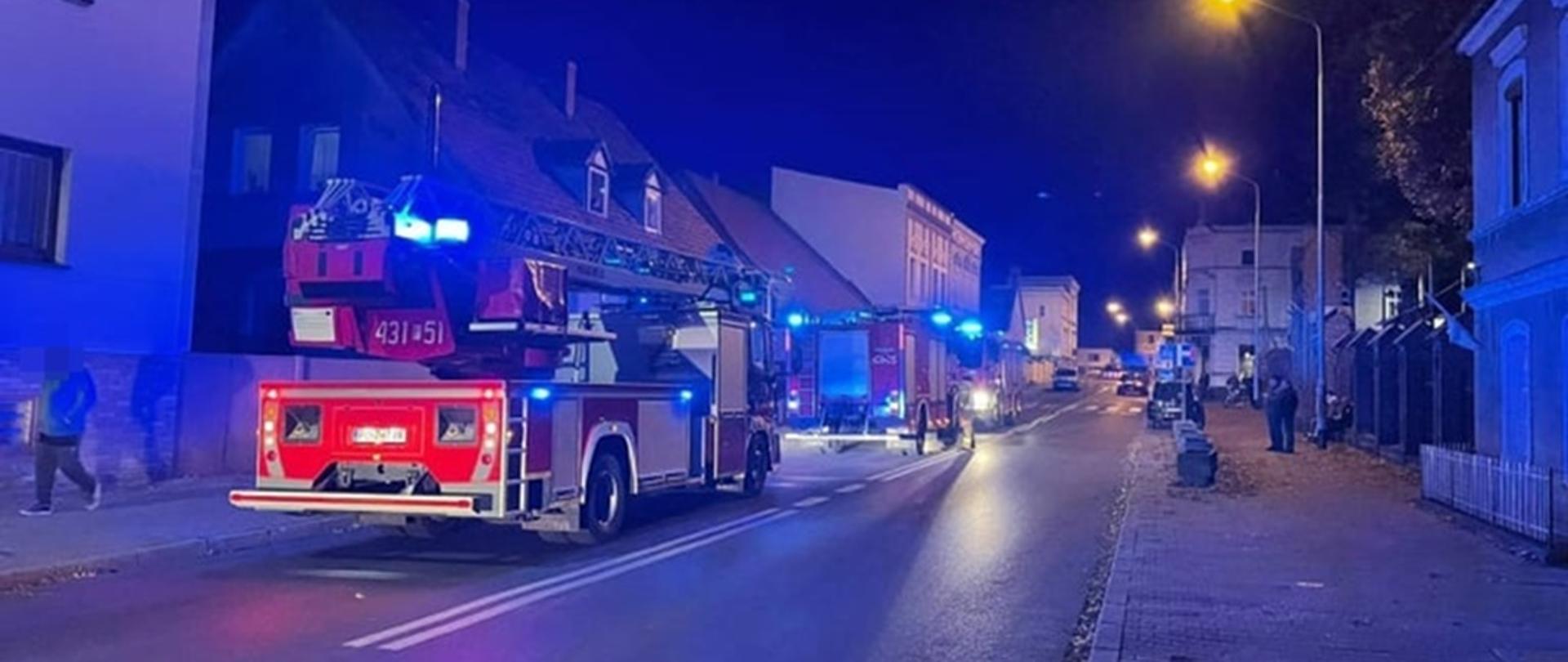 Zdjęcie przedstawia samochody pożarnicze stojące na drodze.