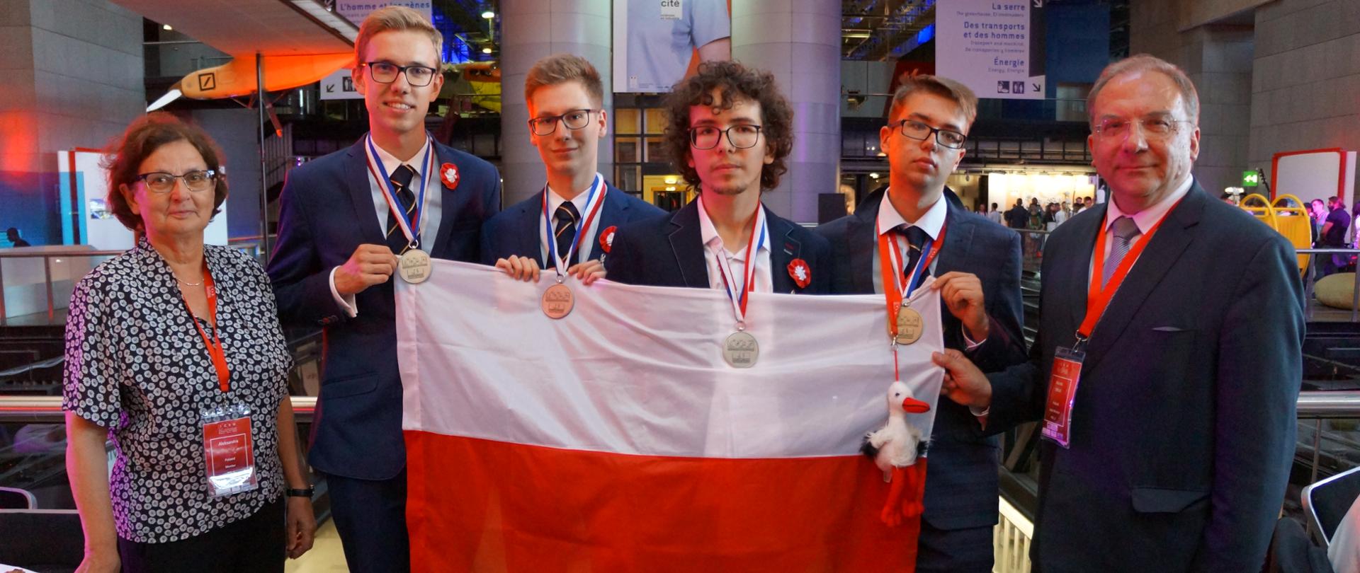 Reprezentacja Polski w Olimpiadzie Chemicznej w Paryżu stoją trzymając flagę Polski