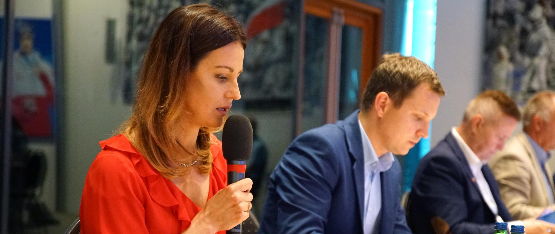 Minister Danuta Dmowska-Andrzejuk przemawia do mikrofonu. 