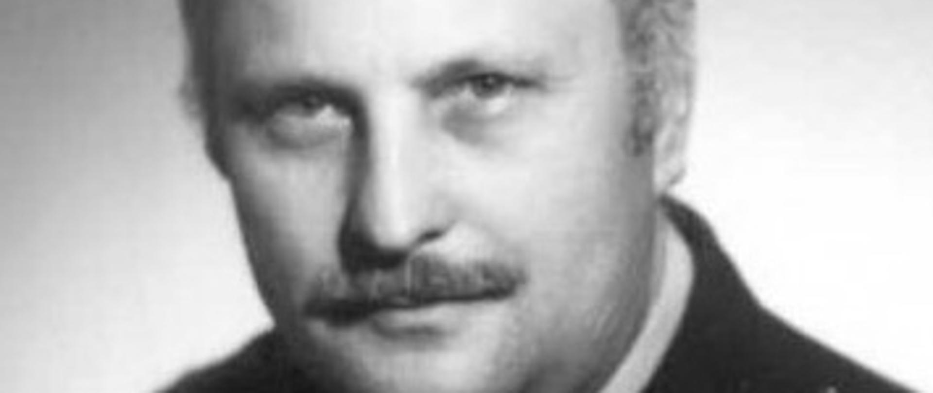 czarno-białe zdjęcie strażaka w mundurze w białej koszuli z krawatem
