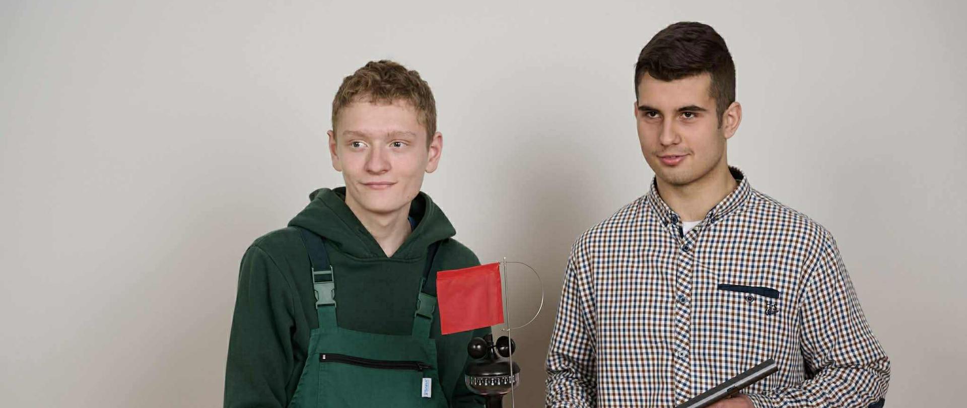 Dwóch chłopców patrzy w prawym kierunku, jeden w ręku trzyma urządzenie meteorologiczne a drugi tablet