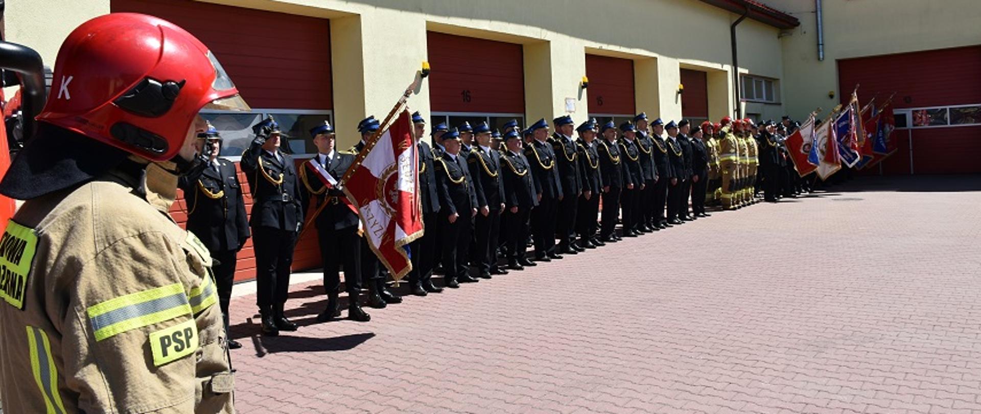 Na zdjęciu widzimy pododdział strażaków z powiatu skarżyskiego podczas podnoszenia flagi państwowej na maszt.