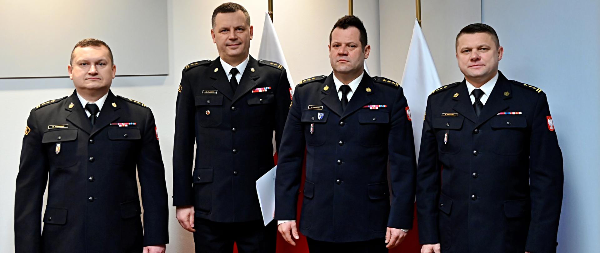 st. bryg. Artur Gonera - MKW PSP, st. bryg. Paweł Potucha - Komendant Powiatowy PSP w Zwoleniu, bryg. Marcin Płachta - p.o. Zastępcy Komendanta Powiatowego PSP w Zwoleniu i st. bryg. Marcin Konecki - Naczelnik Wydziału Kadr KW PSP pozują do wspólnego zdjęcia.