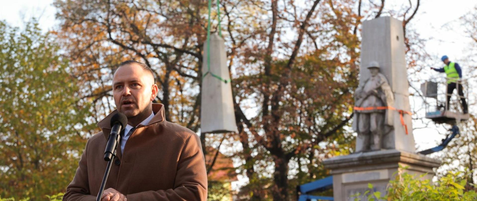 Stojący mężczyzna na tle pomnika 