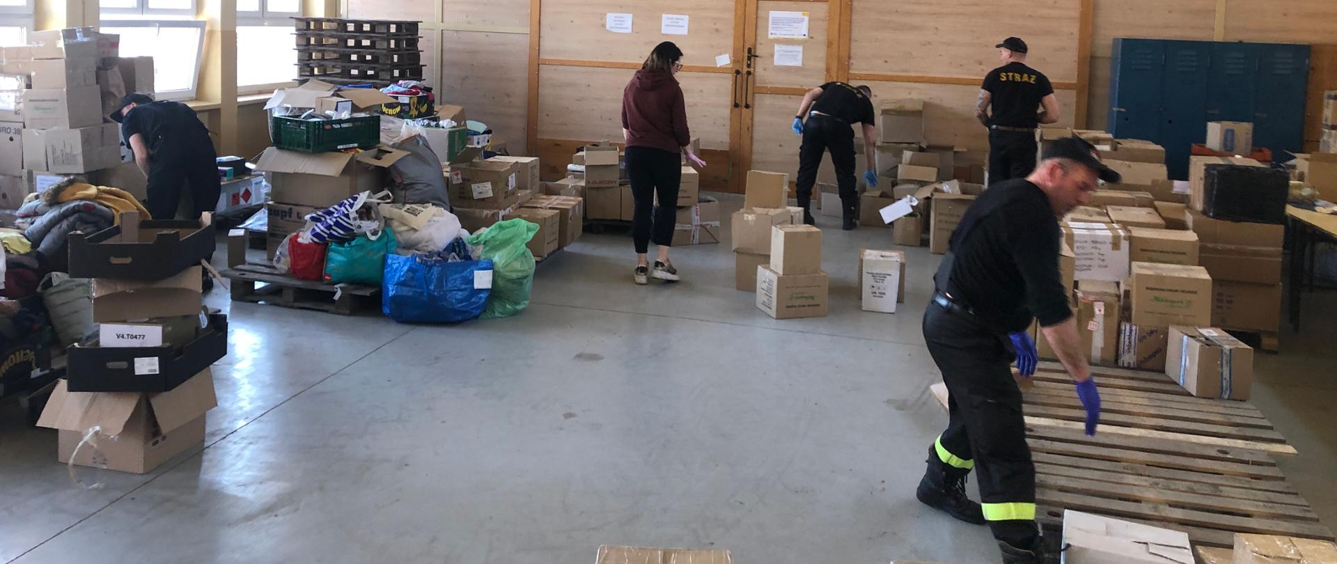 Strażacy pomagają segregować zgromadzone materiały